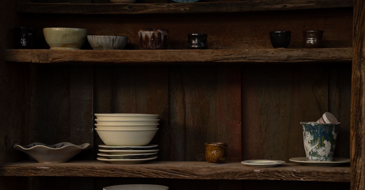 An assortment of vintage ceramics on rustic wooden shelves in Apache Junction, Arizona.
